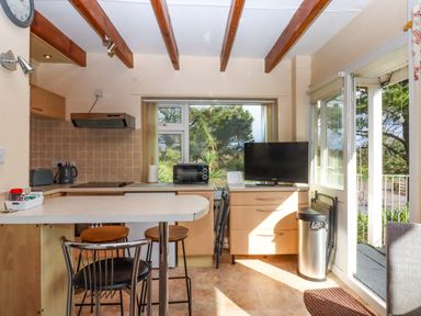 A kitchen with appliances and seating at Flat 1 Lee Cliff Park Dawlish Warren
