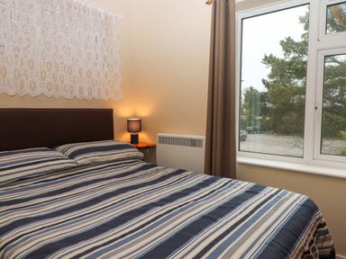 A bedroom with a window and bed at Flat 1 Lee Cliff Park in Dawlish Warren