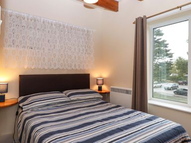 A bedroom with a bed and window at Flat 1 Lee Cliff Park, Dawlish Warren