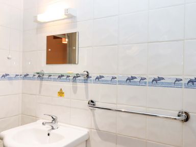 A bathroom with a sink and mirror at Flat 1 Lee Cliff Park in Dawlish Warren