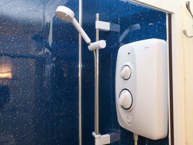A shower with a wall-mounted showerhead and control valve at Flat 1 Lee Cliff Park Dawlish Warren