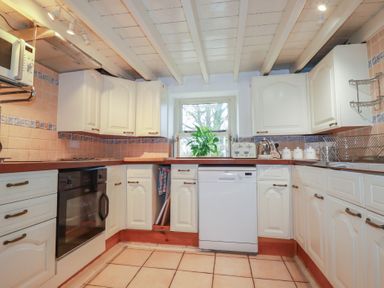 A kitchen with cabinets and appliances at Plenteth in Truro