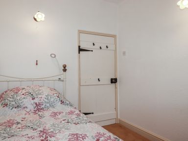A bedroom with a bed and door at Plenteth in Truro