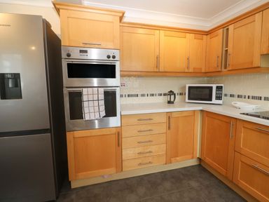 A kitchen with refrigerator, oven, microwave, and cabinets at 16 Forth An Nance Redruth