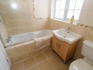A bathroom with a bathtub, sink, and toilet at 16 Forth An Nance in Redruth