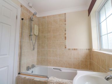 A bathroom with a bath and shower at 16 Forth An Nance in Redruth