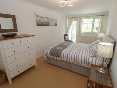 A bedroom with a bed and dresser at 16 Forth An Nance in Portreath