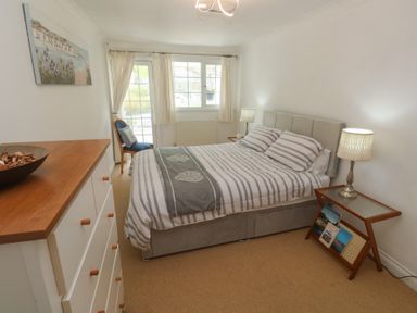 A bedroom with a bed and dressing table at 16 Forth An Nance in Portreath