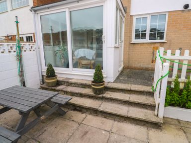 A patio area with a table and steps at 16 Forth An Nance, Portreath