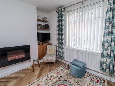 A living room with a fireplace and a TV at 55 Meldon terrace in Newbiggin-by-the-Sea