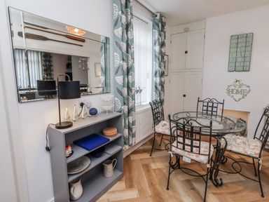 A dining room with a table and chairs at 55 Meldon terrace in Newbiggin-by-the-Sea