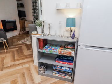 A living room with a bookshelf displaying board games at 55 Meldon terrace Newbiggin-by-the-Sea