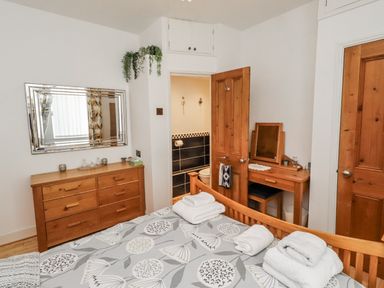 A bedroom with a bed and dresser at 55 Meldon terrace Newbiggin-by-the-Sea