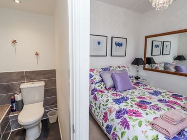 A bedroom with a bed and a bathroom featuring a toilet at 55 Meldon terrace Newbiggin-by-the-Sea