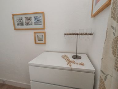 A chest of drawers with glasses and beads on top at 55 Meldon terrace in Newbiggin-by-the-Sea