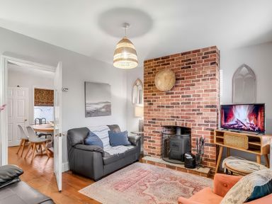 A living room with a sofa and television at Bay Tree Cottage in Heacham