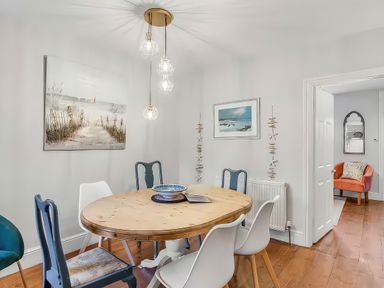 A dining room with a round table and chairs at Bay Tree Cottage in Heacham
