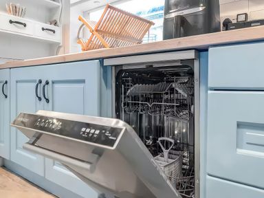 A kitchen with a dishwasher and dish rack at Bay Tree Cottage Heacham