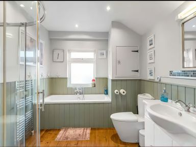 A bathroom with a bathtub, shower, sink, and toilet at Bay Tree Cottage in Heacham