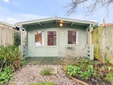 A cabin with a deck and garden at Bay Tree Cottage in Heacham