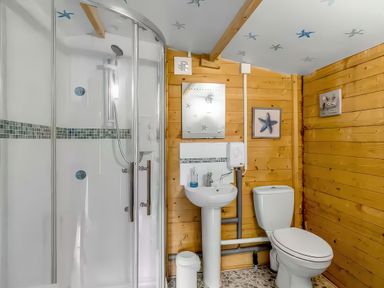 A bathroom with a shower, sink, and toilet at Bay Tree Cottage in Heacham