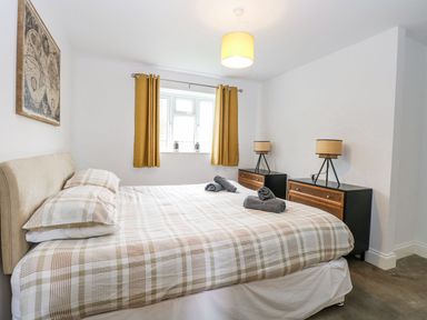A bedroom with a bed and nightstands at The Ivy in Norwich