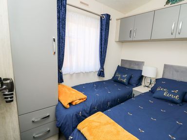 A bedroom with two beds and a window at 33 Woodpecker Lodge in Llanarth