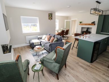 A living room with a sofa and coffee table at Doire Fhatharta Beag in Carraroe, County Galway