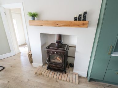 A living room with a wood stove and fireplace at Doire Fhatharta Beag, Carraroe, County Galway