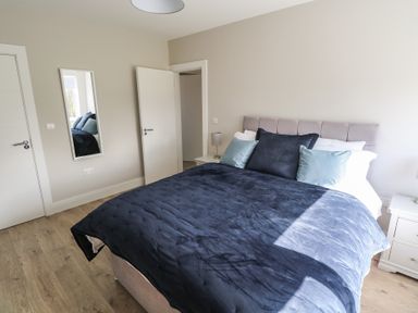 A bedroom with a bed and bedside table at Doire Fhatharta Beag, Carraroe, County Galway