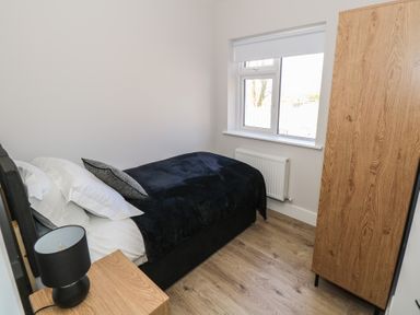 A bedroom with a bed and wardrobe at Doire Fhatharta Beag, Carraroe, County Galway