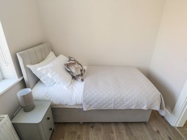 A bedroom with a bed and nightstand at Doire Fhatharta Beag in Carraroe, County Galway