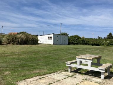 A garden with a table and a shed at Seadrift Bush Estate near Happisburgh