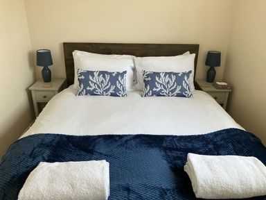 A bedroom with a bed and nightstand at Seadrift near Happisburgh