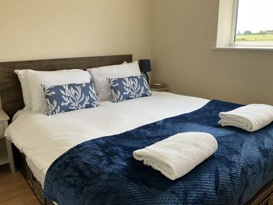 A bedroom with a bed and pillows at Seadrift near Happisburgh