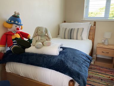 A bedroom with a single bed and stuffed toys at Seadrift Bush Estate near Happisburgh
