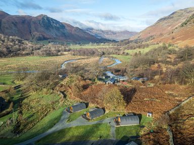 An aerial view of a landscape with cabins and a river at Bluebelle - Crossgate Luxury Glamping Hartsop