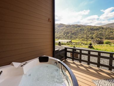A hot tub on a deck with a view of mountains at Bluebelle - Crossgate Luxury Glamping in Hartsop