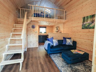 A living room with a staircase and sofa at Bluebelle - Crossgate Luxury Glamping Hartsop