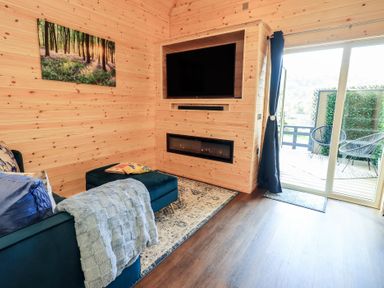 A living room with a sofa and television at Bluebelle - Crossgate Luxury Glamping Hartsop
