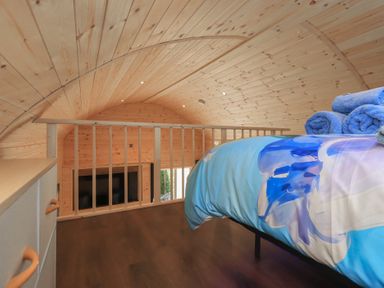 A loft bedroom with a bed and towels at Bluebelle - Crossgate Luxury Glamping Hartsop