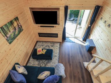 A living room with a television and sofa at Bluebelle - Crossgate Luxury Glamping Hartsop