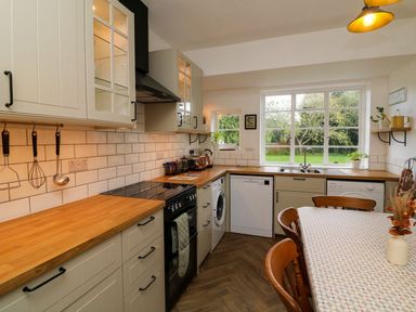 A kitchen with cabinets, a stove, and a sink at Barton Lodge in Porlock