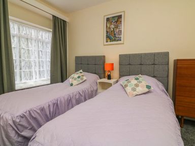 A bedroom with two beds and a window at Barton Lodge in Porlock