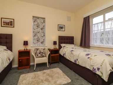A bedroom with two single beds and nightstands at Barton Lodge in Porlock