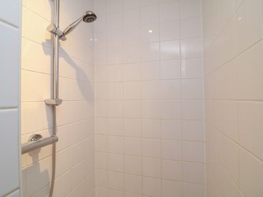 A shower with white tiles and a showerhead at Fairways 22 in Lincoln