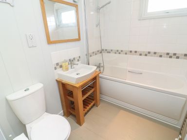 A bathroom with a toilet, sink, bathtub, and shower at Fairways 22 in Lincoln