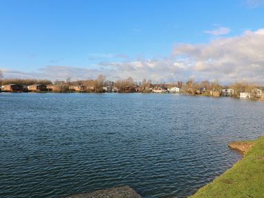 A view of a lake with houses and trees at Fairways 22, Lincoln
