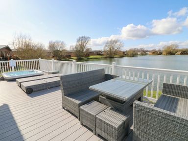 A deck with outdoor furniture and a hot tub at Fairways 22 in Tattershall