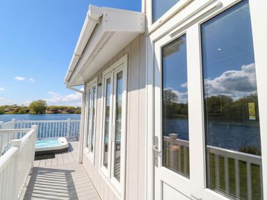 An outdoor area with a hot tub and view of water at Fairways 22 in Tattershall